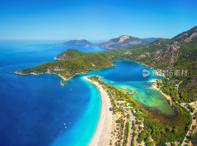 土耳其Oludeniz令人惊叹的蓝礁湖鸟瞰图。在阳光明媚的日子里，夏天的风景有山，绿色的森林，蔚蓝的水，沙滩和蓝天。旅游的背景。前视图。自然