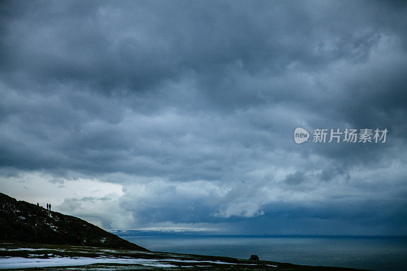 人们在暴风雨天气下在美丽的冬季山脉徒步旅行