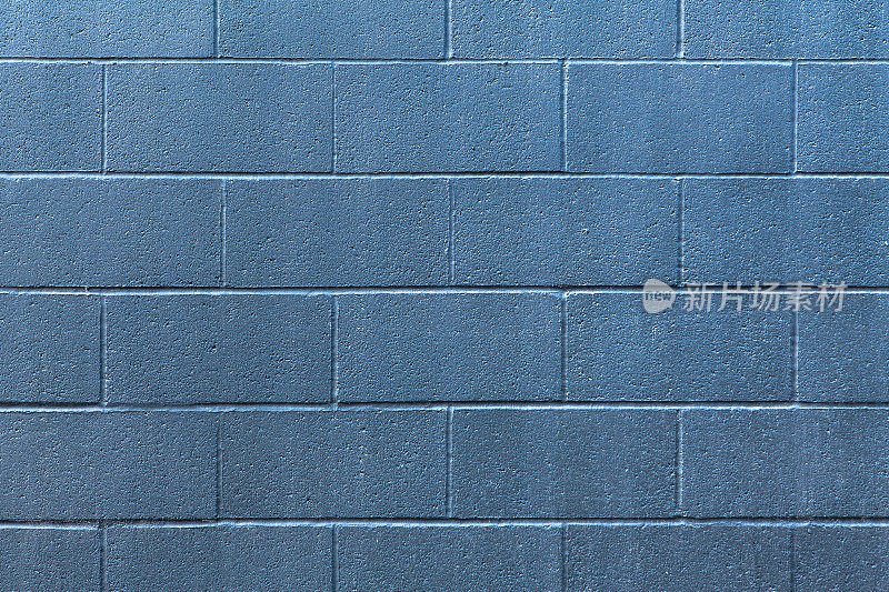 一堵涂着浅蓝色银色的混凝土砌块墙