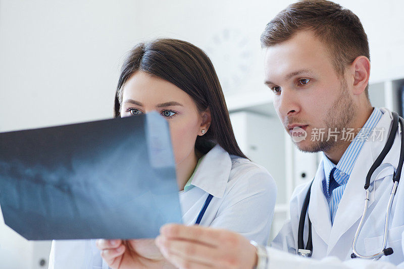 男女医生讨论x光影像。