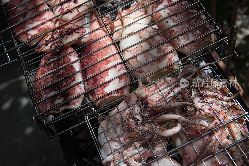 新鲜健康的章鱼和鱿鱼海鲜在木炭烧烤。