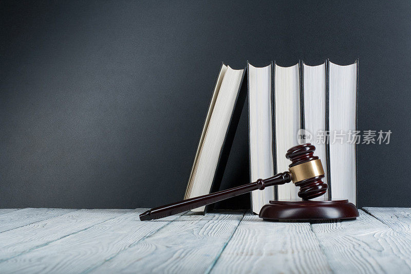 法律概念-在法庭或执法办公室的桌子上打开一个木制法官木槌的法律书，在白色的背景上孤立。文本复制空间