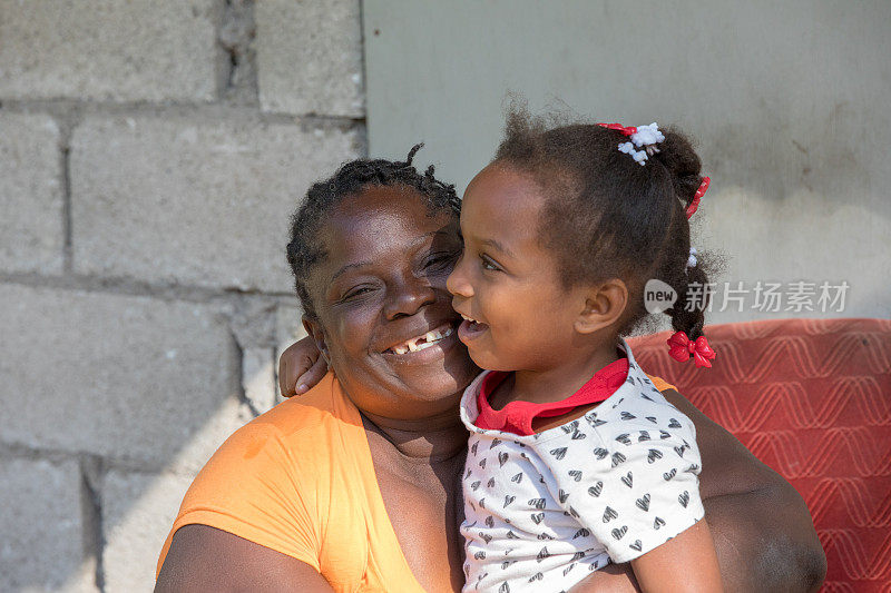 一个来自偏远村庄的牙买加母亲拥抱她的小女儿的肖像