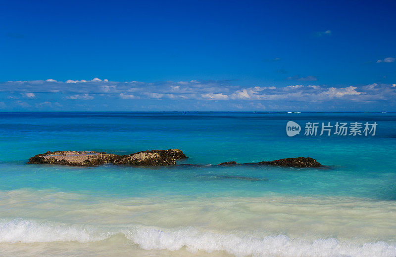 加勒比海与海浪打破海岸，蓝色和蓝绿色的水和蓝色的天空，坎昆，墨西哥。