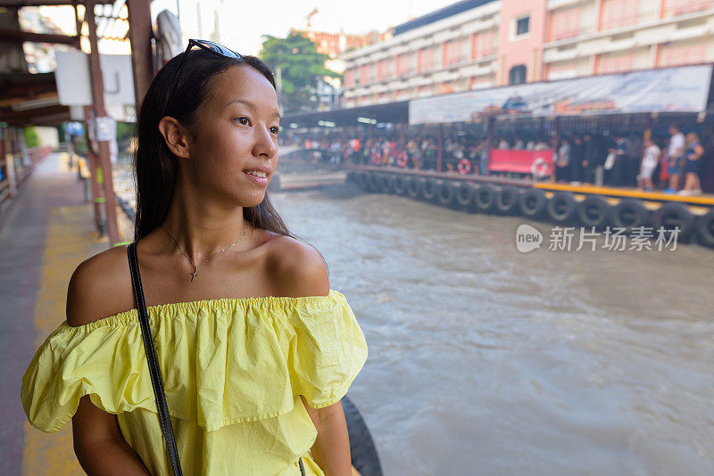 年轻美丽的多民族旅游妇女的肖像在水出租车站在泰国曼谷