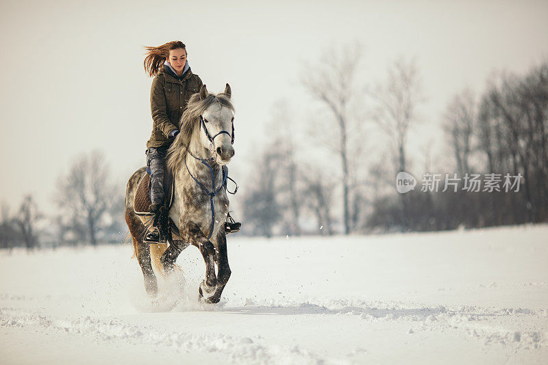 一个女人在雪地里骑马