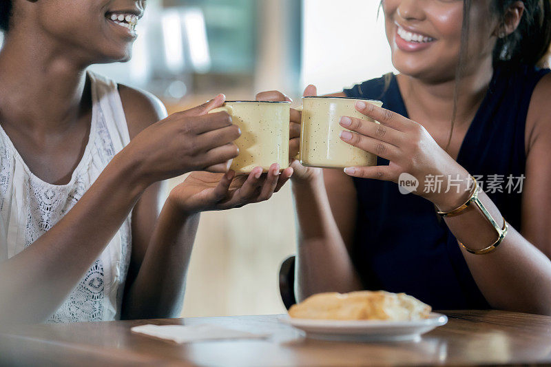 年轻女性在当地的咖啡馆或餐厅享用一杯热咖啡