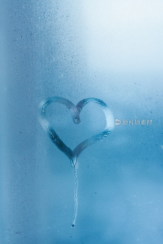 玻璃上的心和水珠。窗户上的水珠