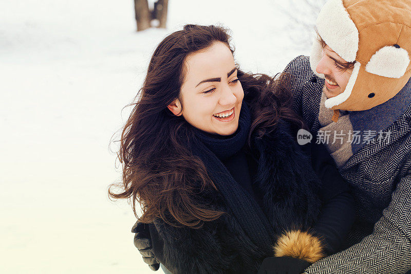 一对年轻夫妇在雪中玩耍