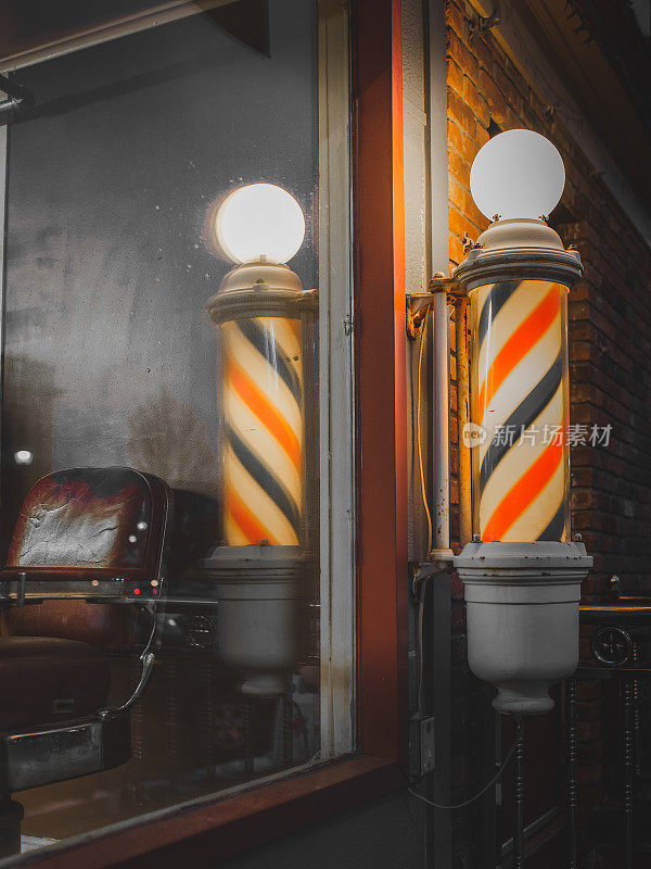 橱窗里有点亮的理发店杆和古董理发椅