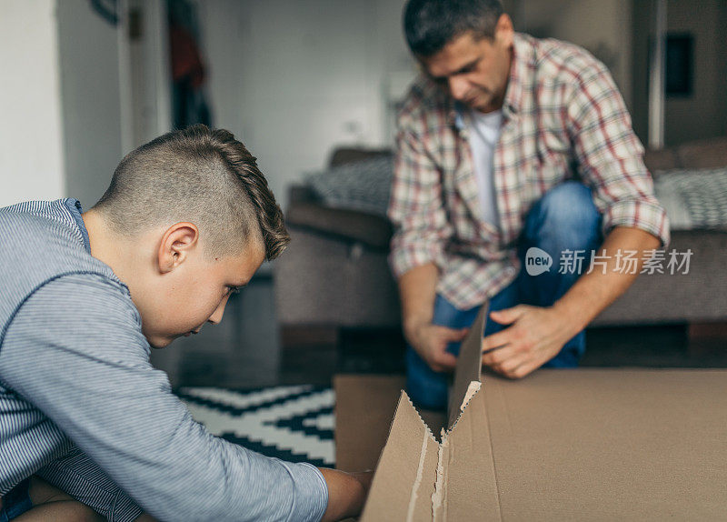 一位单身父亲正在和他的孩子组装家具