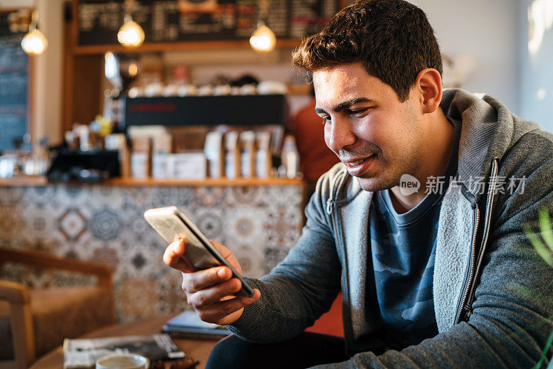 一名男子在咖啡店里发短信