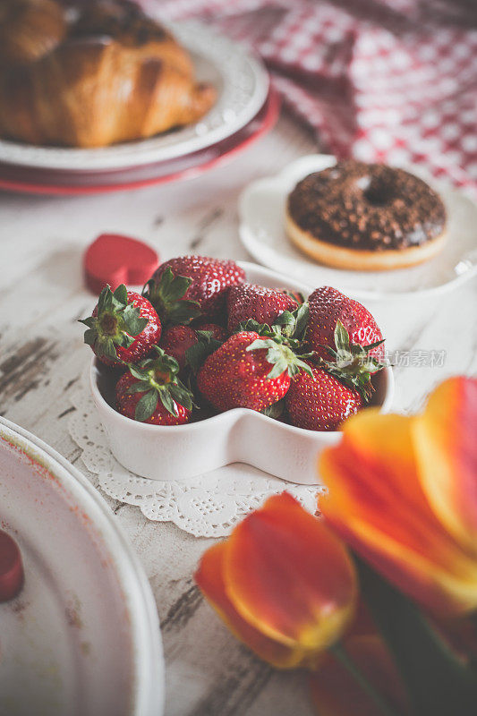 碗里装草莓和巧克力甜甜圈