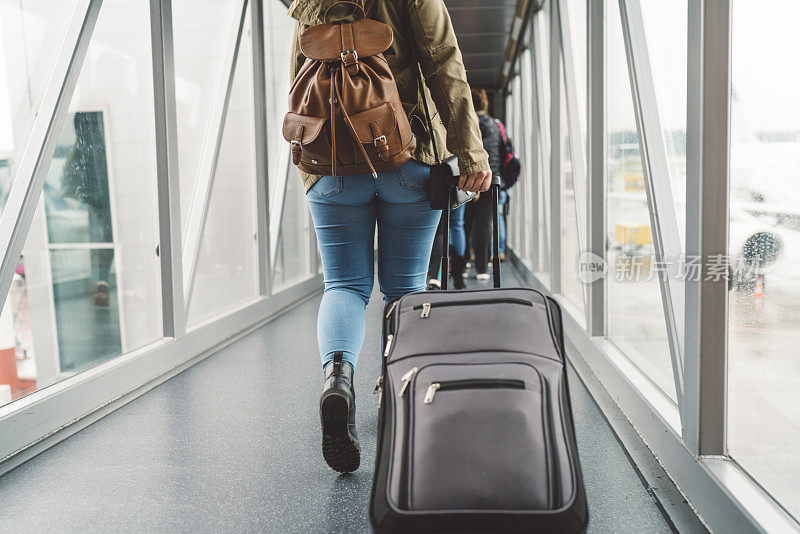 一名年轻女子在登机前拉着手提箱