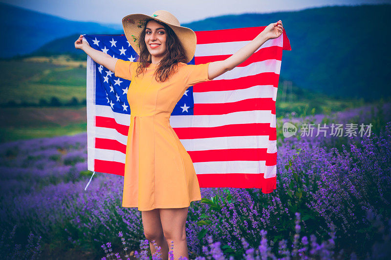 年轻快乐的女孩举着美国国旗