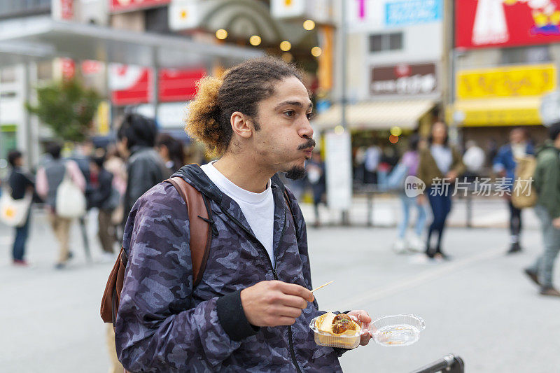 日本东京，一名男子在街上吃外卖