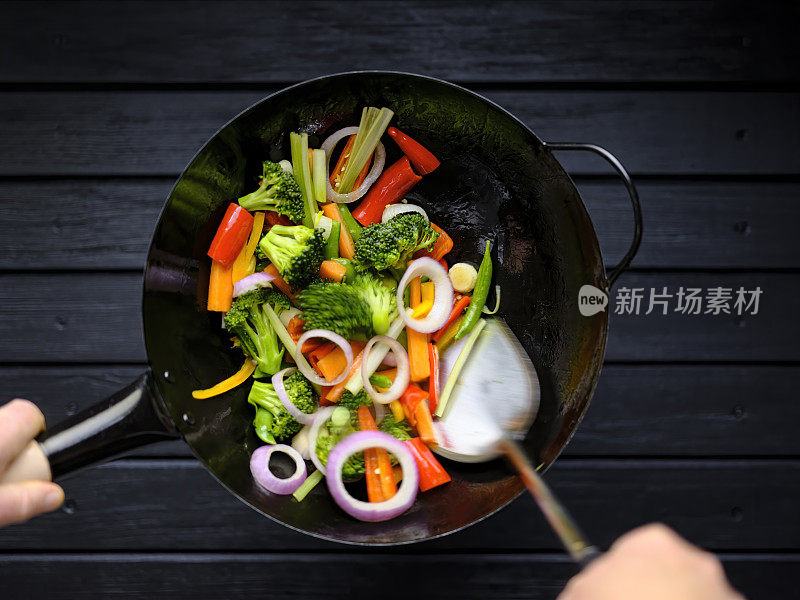 在热锅中煸炒各种新鲜的蔬菜。