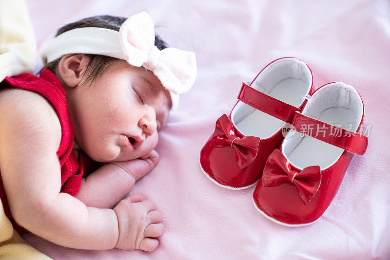 刚出生的女婴在睡觉，而她的第一双鞋就在她身边
