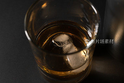 黑色的桌子上放着威士忌水晶杯