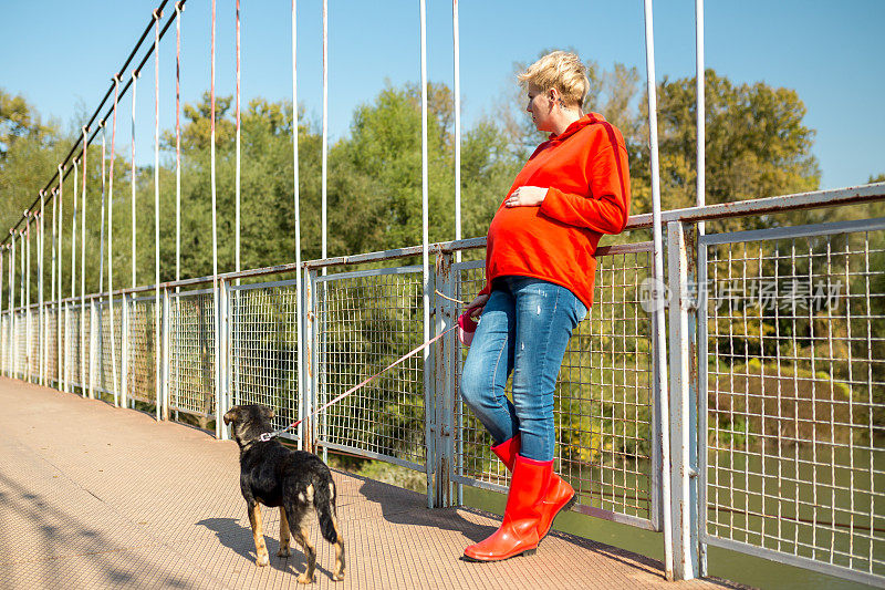 孕妇喜欢在公园里遛狗。