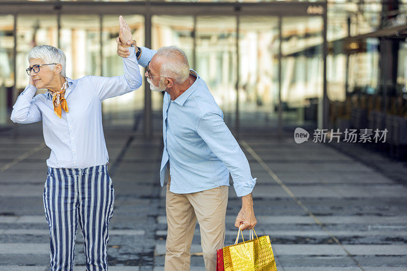 购物失败后，一对成年夫妇在街上拿着纸袋