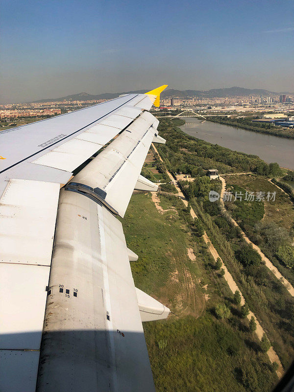 从飞机窗口望去，背景是西班牙加泰罗尼亚的巴塞罗那略布雷加特河和纳尔逊曼德拉大桥