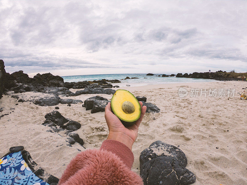 在海滩上拿着牛油果的女人的个人观点