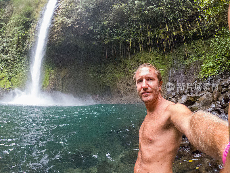 一名年轻人在哥斯达黎加的瀑布中自拍