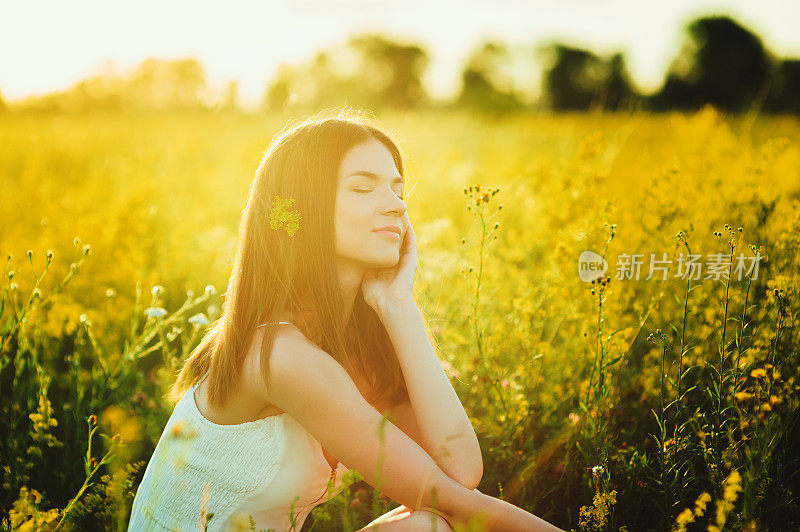 美丽无忧无虑的女孩在夏天的花海中