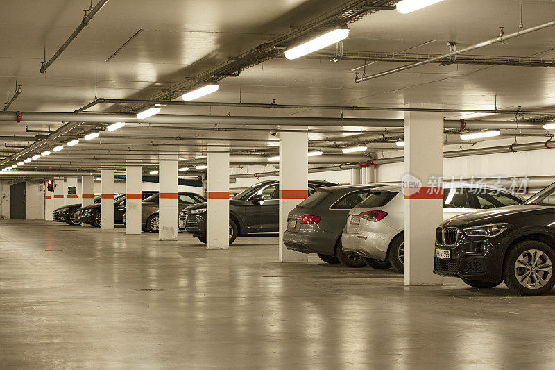 地下停车场在一个现代建筑的地下停车场与汽车排。丹麦哥本哈根，2020年5月20日。