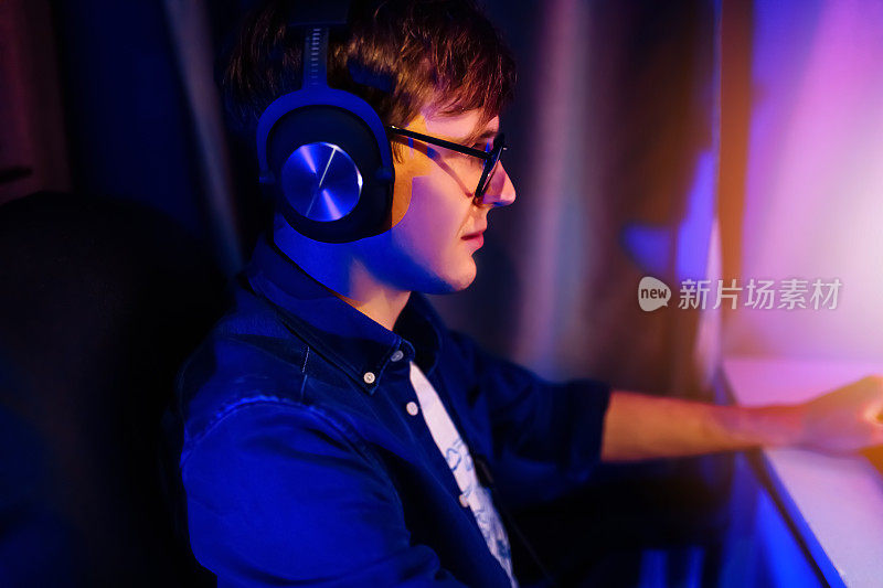 玩家坐在有霓虹灯的房间里，以个人电脑的第一人称玩在线视频游戏。网络体育锦标赛。