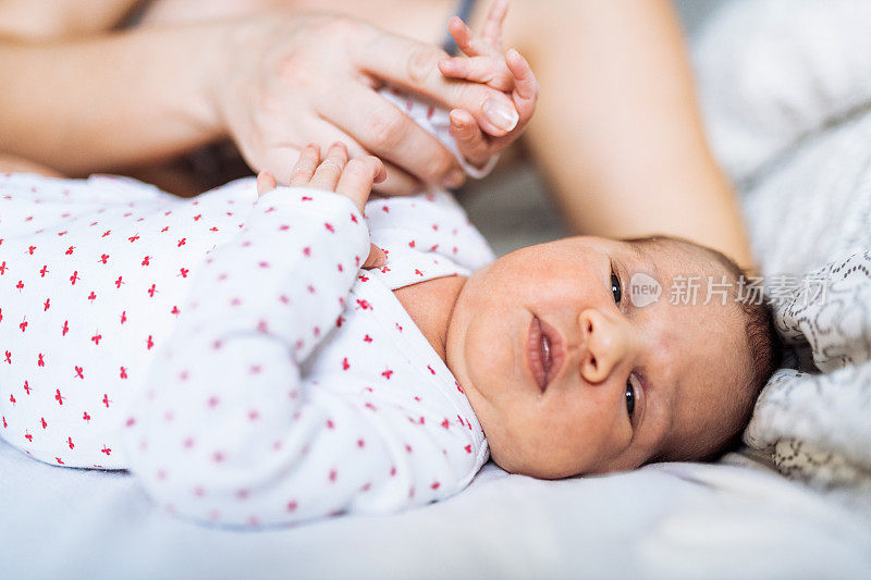 妈妈抱着刚出生的女儿玩耍