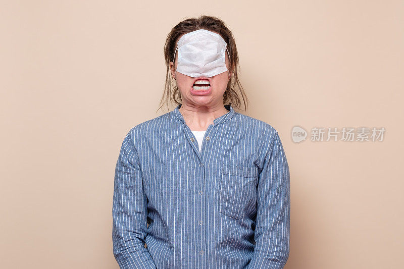 白种年轻女子用医疗masl遮住她的眼睛受到惊吓和压力