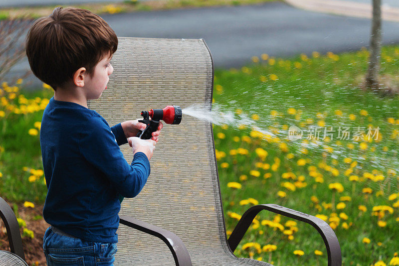 男孩为家花园浇水