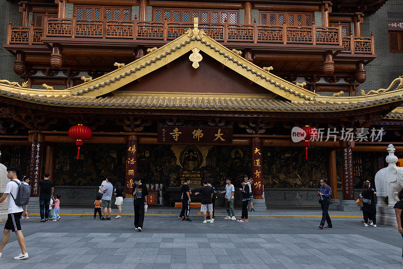 今。北京大街附近的中式寺庙。人们在寺庙附近散步，给它拍照。