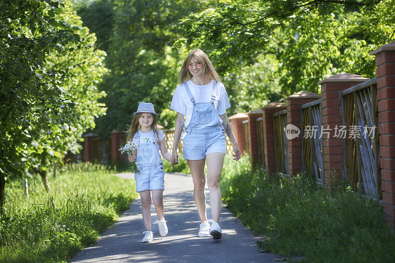 在阳光明媚的日子，母亲和女儿在公园散步