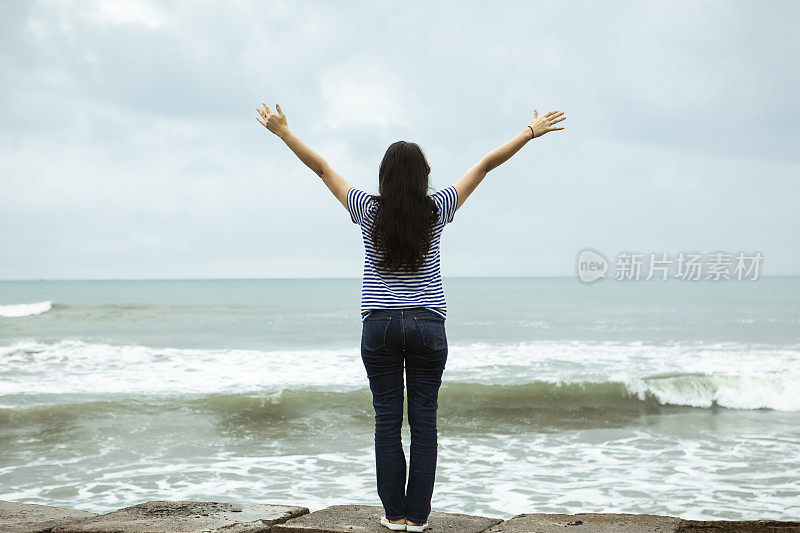 一个悲伤孤独的女人站在印度洋前