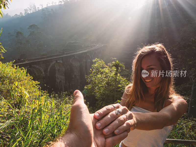 在斯里兰卡日出时，一对夫妇在桥附近牵着手