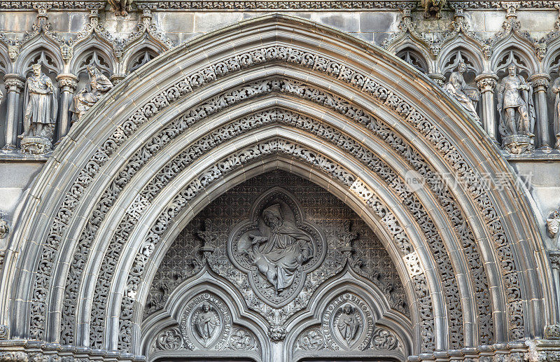 圣吉尔斯大教堂入口处的蓟教堂上方的装饰石雕拱门的风景如画的外部景观。