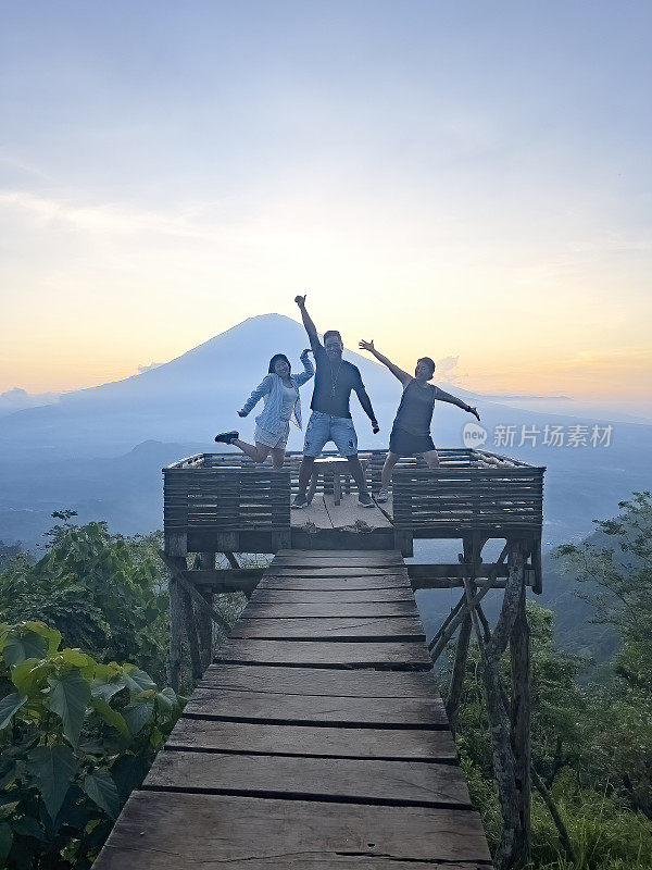 导游，多民族游客在山上观赏日落