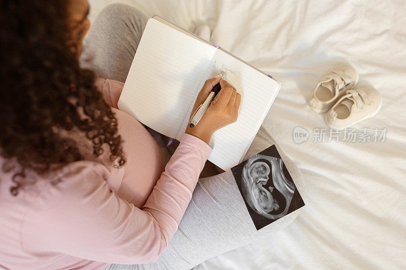 未来的母亲写日记，旁边是婴儿的超声波图和小鞋子