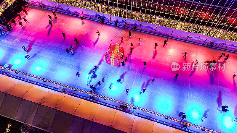 许多人在户外街道的溜冰场上滑冰，鸟瞰圣诞节时阿姆斯特丹市中心的溜冰场，人们在冰上滑冰，圣诞滑冰，欧洲冬季运动