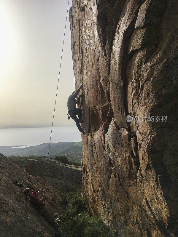 成熟的男人用绳子爬悬崖