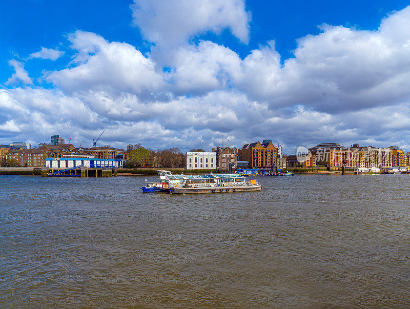 从伦敦泰晤士河上看，载着乘客和游客的游船，用链条锚定在伦敦码头上。联合王国。
