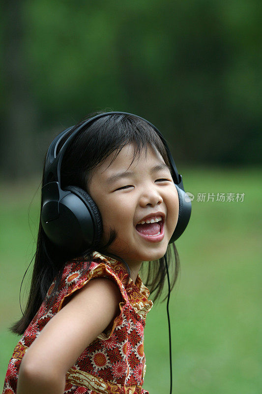 女孩在公园边听边唱