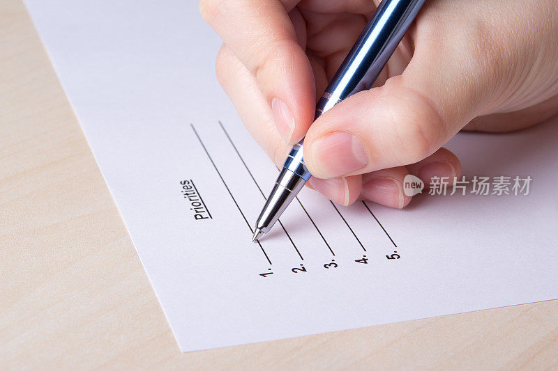 特写女性用钢笔手工填写优先级列表