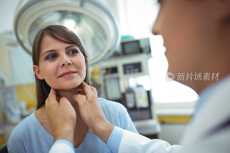 医生检查一位女性病人的颈部