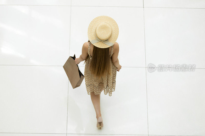 在购物中心散步的女人。从上往下看
