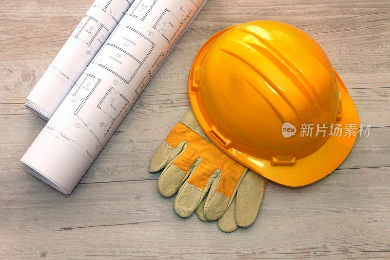 施工现场工作场所安全方案:黄色安全帽，建筑蓝图，手套