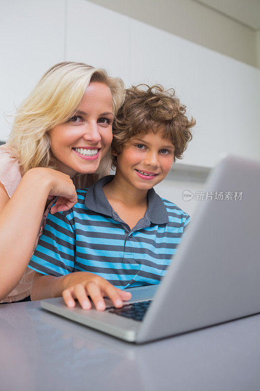 微笑的母子使用笔记本电脑